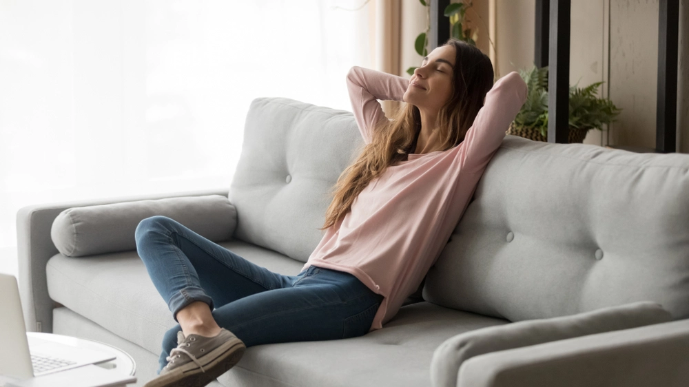 Woman relaxes on couch.
