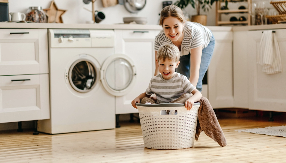 An image shows a picture of a mother having fun with his son at their laundry room.