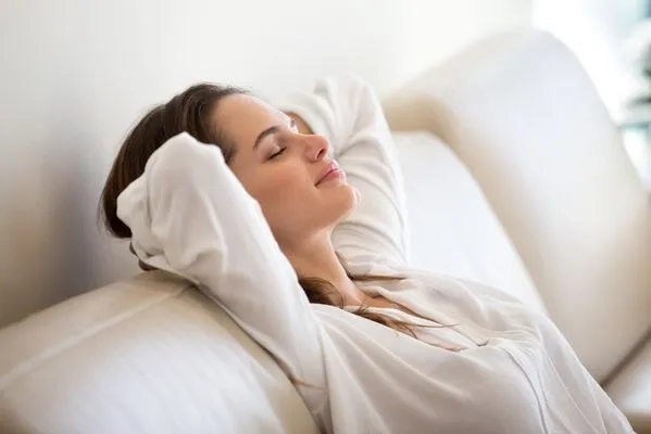 How Long Does An AC Tune-up Take - Image of a lady happily smiling while enjoying much cooler and fresher air.