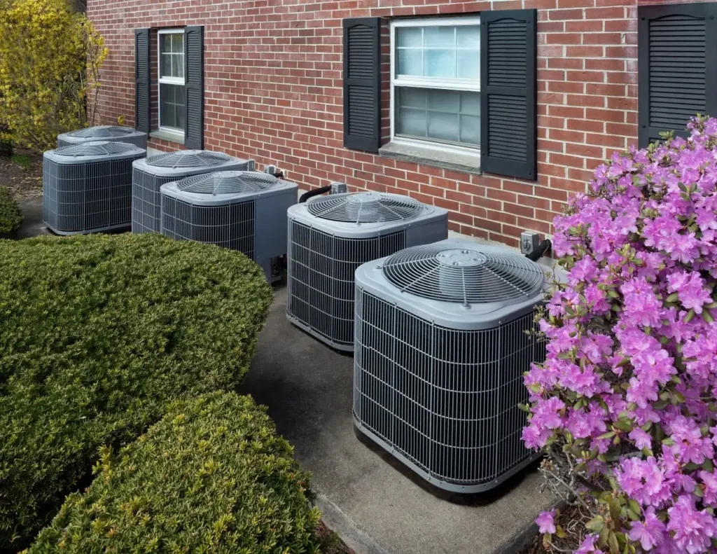 an image of multiple central air conditioner units installed outside a brick home
