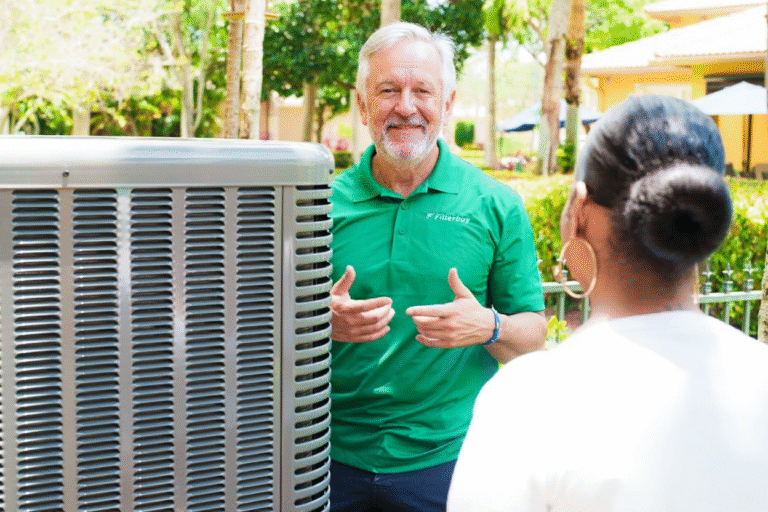 Image of a Filterbuy HVAC technician discussing new air conditioning installation with a homeowner outside, showcasing professional HVAC service and customer care.